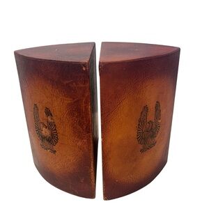 vintage leather-wrapped wood bookends featuring a stamped eagle design.